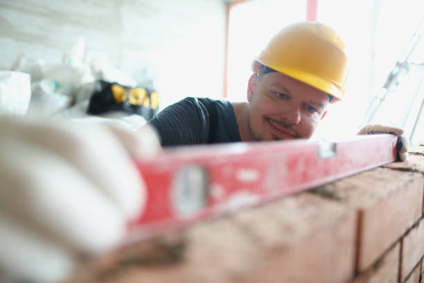 istock Professional male builder measure distance on wall with level tool, concrete barrier 1372048597