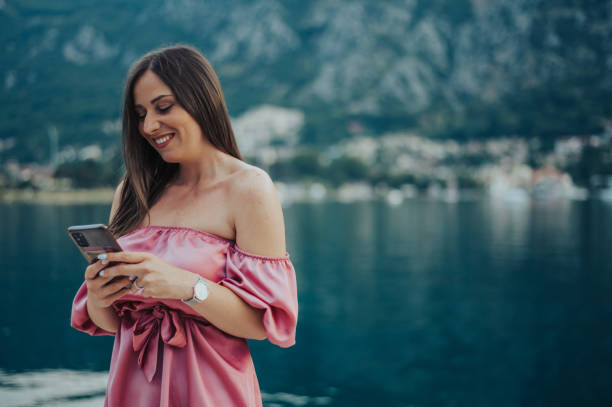 istock Woman using smartphone while walking on the city streets on the coast 1372048795