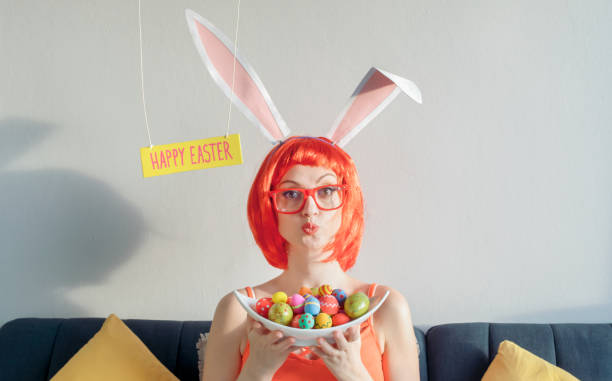 mujer con orejas de conejo y sosteniendo huevos de pascua - easter easter bunny fun humor fotografías e imágenes de stock