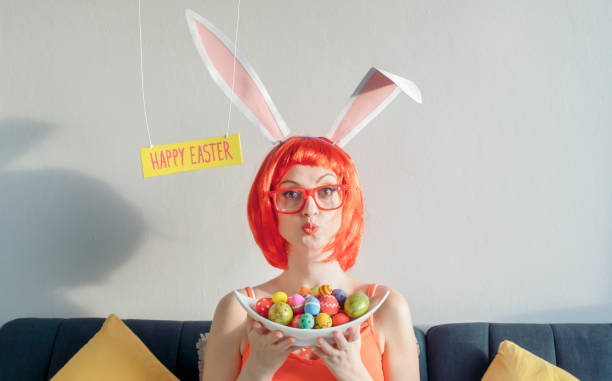 Woman wearing bunny ears and holding Easter eggs
