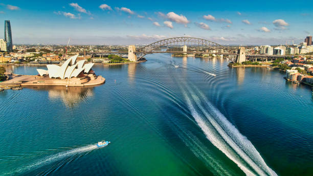 boat wakes im hafen von sydney mit opernhaus und brücke im hintergrund - australia new south wales aerial view landscape stock-fotos und bilder