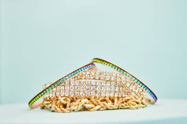 Collection of gold and silver jewelry in a bright blue studio setting with space for copy