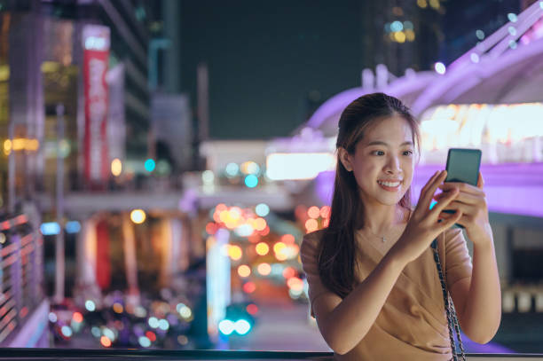 istock Asian using digital device smile cheerful postive emotion with city background 1372054960