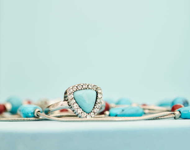 istock Turquoise and silver ring with beaded necklace in a bright studio setting with blue background. Western style jewelry 1372057967