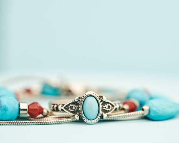 istock Turquoise and silver ring with beaded necklace in a bright studio setting with blue background. Western style jewelry 1372057979