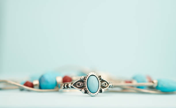 istock Turquoise and silver ring with beaded necklace in a bright studio setting with blue background. Western style jewelry 1372057988