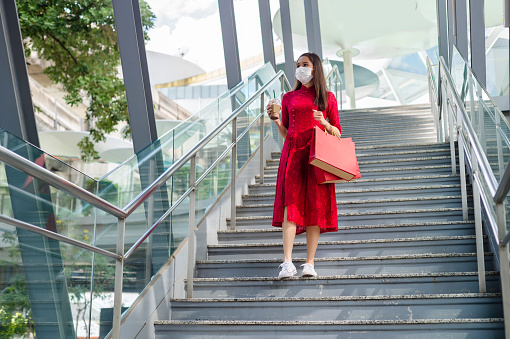 Asian women in red dress (Qipao) shopping in malls on vacation live a new normal in the capital, travel in the capital Epidemic Prevention in Bangkok, Thailand