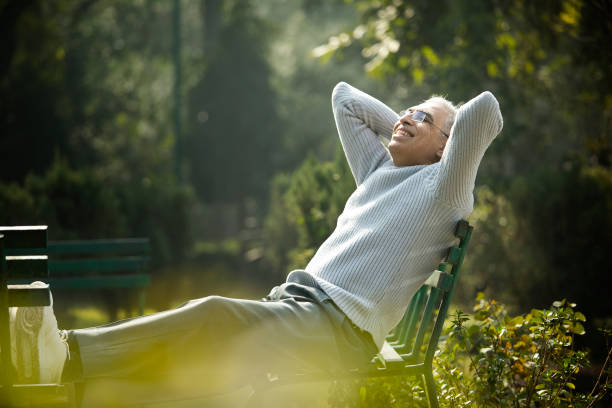 istock Happy senior man relaxing at park 1372061640