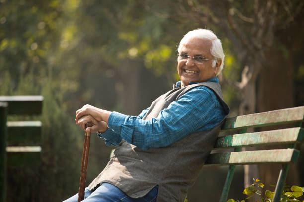 istock Happy senior man sitting at park 1372061669