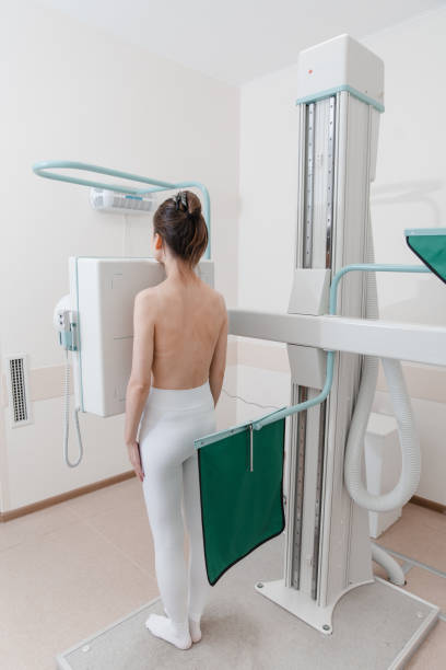 Hospital Radiology Room. Xray machine for fluorography. Woman patient scanning chest, heart or lungs in clinic office. Adult female undergoes healthcare exam. Medical X-ray equipment for radiography. sala de radiología del hospital. máquina de rayos x para fluorografía. paciente mujer que escanea el tórax, el corazón o los pulmones en el consultorio de la clínica. la mujer adulta se somete a un examen de atención médica. equipo médico de rayos