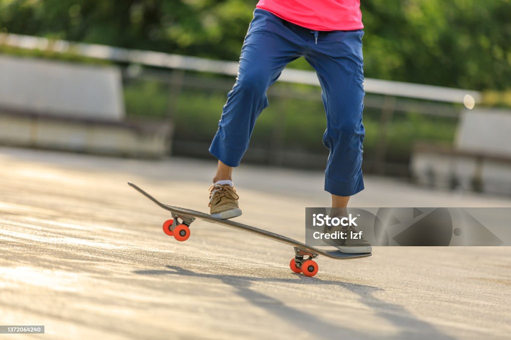 Asian woman skateboarder skateboarding in modern city Skateboarding Stock Photo