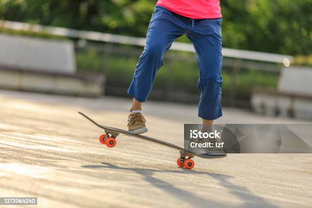 Asian Woman Skateboarder Skateboarding In Modern City Stock Photo - Download Image Now