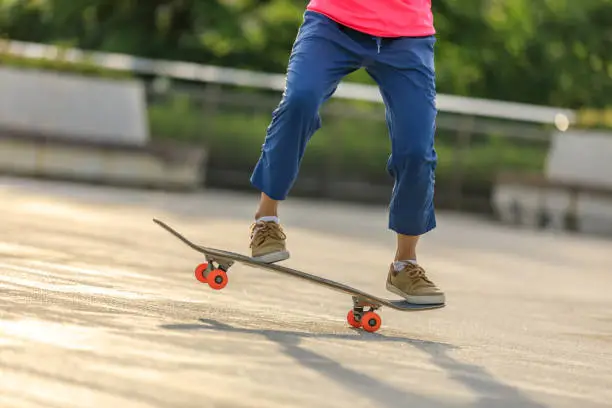 Photo of Asian woman skateboarder skateboarding in modern city