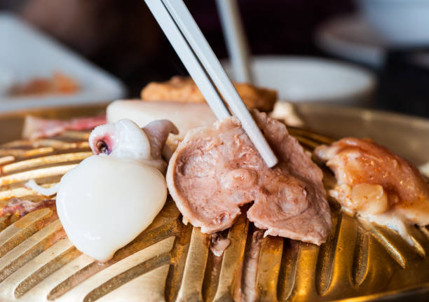 istock The pork is roasted on a barbeque using white chopsticks, where heat and smoke emanate from the dish. 1372065000