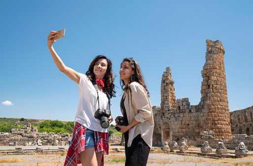 Female friends traveling and taking pictures in Perge, Antalya, Turkey