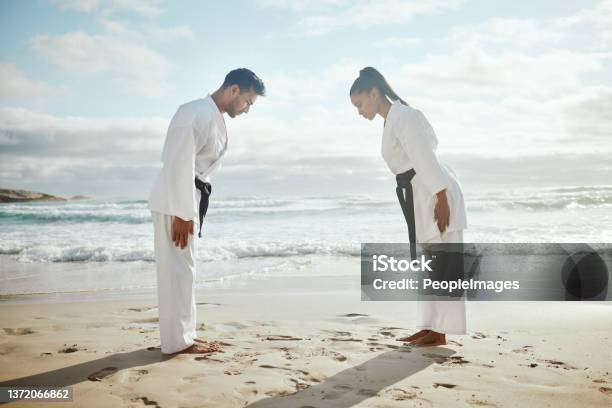 Full Length Shot Of Two Young Martial Artists Practicing Karate On The Beach Stock Photo - Download Image Now