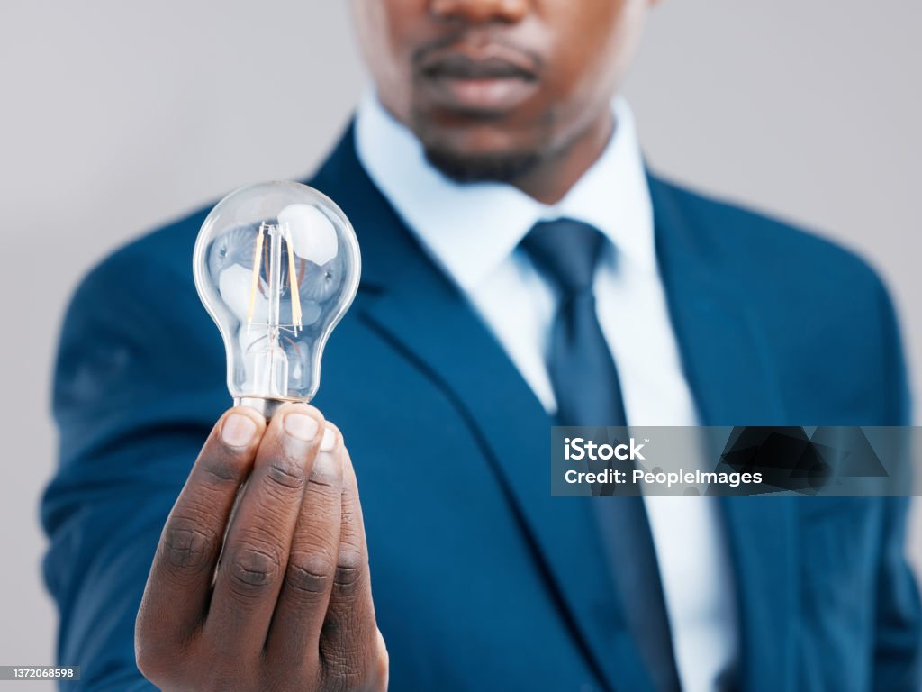 Studio shot of a businessman holding a light bulb against a grey background Your next bright idea could be the beginning of success People Stock Photo