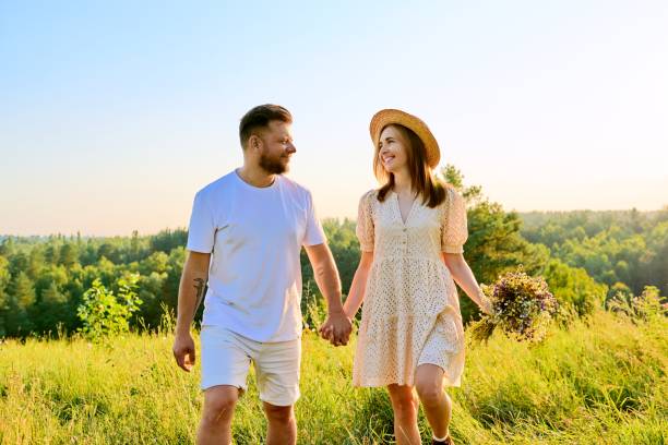 istock Happy middle age couple holding hands, summer nature wild meadow 1372072085