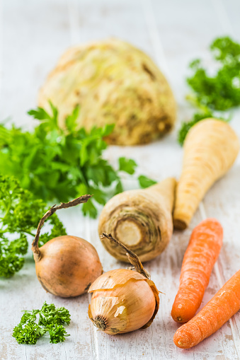 Vegetables and herbs for vegetable stock, soups, vegetable broth. Healthy and homemade food concept. Vertical.