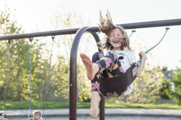 istock Carefree girl laughing while on park swing 1372073183
