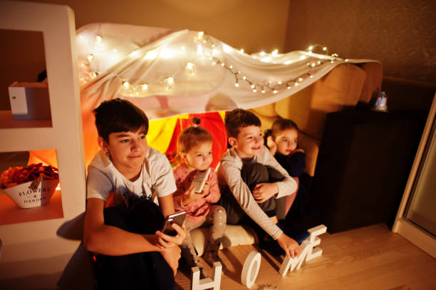 bambini in tenda waching tv a casa di notte. umore hygge. - 12 23 mesi foto e immagini stock