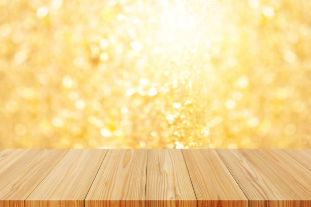 istock Perspective empty wooden table on top over blur gold background, can be used mock up for montage products display or design layout. 1372076061