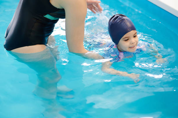 istock Baby swim in blue pool water 1372077085