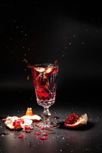 Antique crystal glass with pomegranate juice on a dark background stock photo
