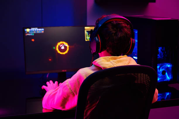 istock Gamer play computer game, use rgb neon colored keyboard 1372077192