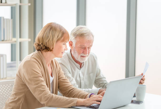 istock Senior couple checking their bills, retired elderly old family reading documents 1372077322