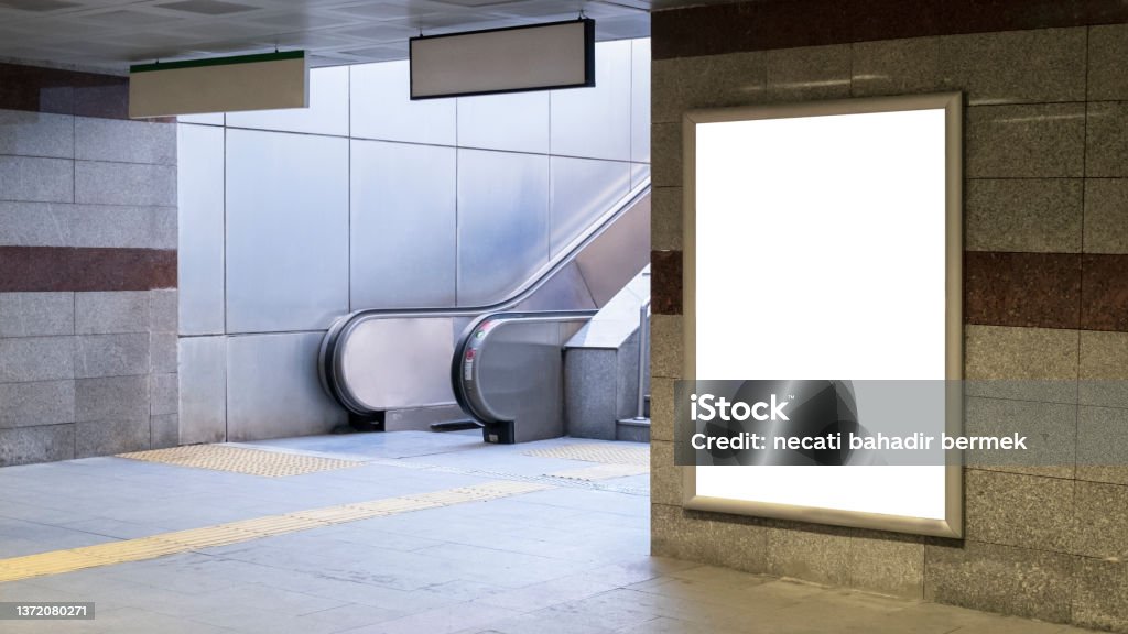 Train station Train station interior with escalator and empty poster on concrete wall Subway Stock Photo