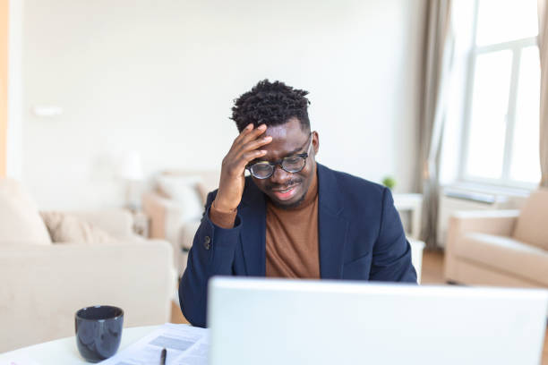 istock Stressed tired African American man touching temples, suffering from headache after long hours work, overworked overwhelmed businessman sitting at desk, feeling unwell 1372080396