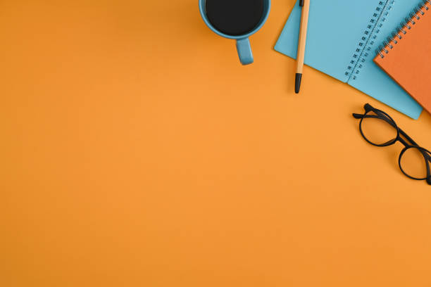 istock Colorful notebook, eyeglasses, coffee cup and pencil on yellow background. 1372081313