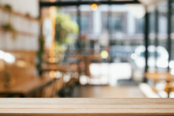 leerer holztisch vor verschwommenem hintergrund des cafés. kopieren sie platz für die ausstellung oder montage ihrer produkte. - brown table inside stock-fotos und bilder