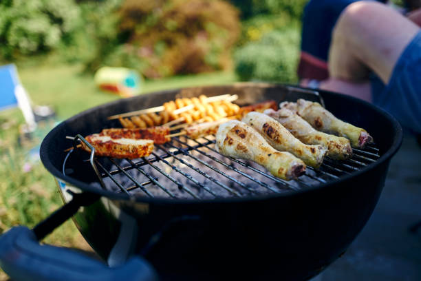 istock Chicken drumsticks and kebabs cooking on a BBQ 1372085156