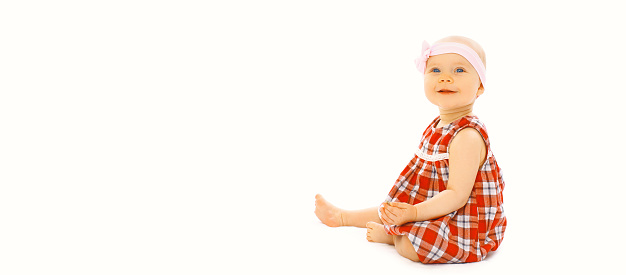 Portrait of cute little baby crawling and playing on floor on white background