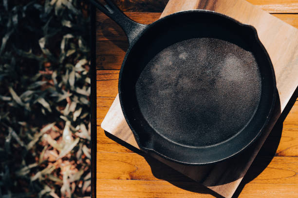 istock Iron pan and camping accessory on wood table. Equipment for camping in forest. In summer with sunlight. 1372091053