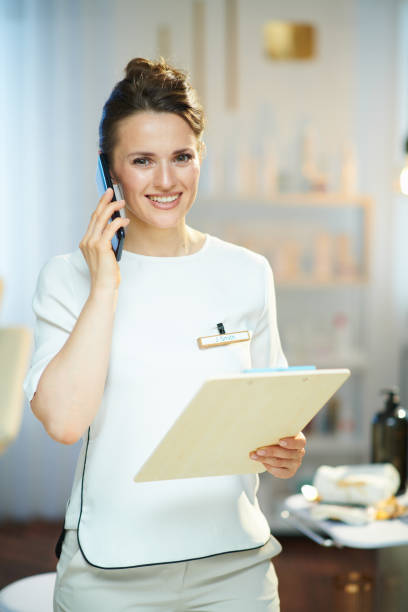 istock smiling woman worker in beauty studio talking on phone 1372091657