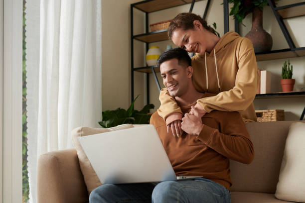 istock Happy couple using laptop at home 1372094125