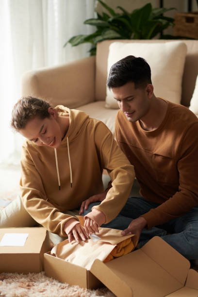 istock Couple unpacking the box with new clothes 1372094184