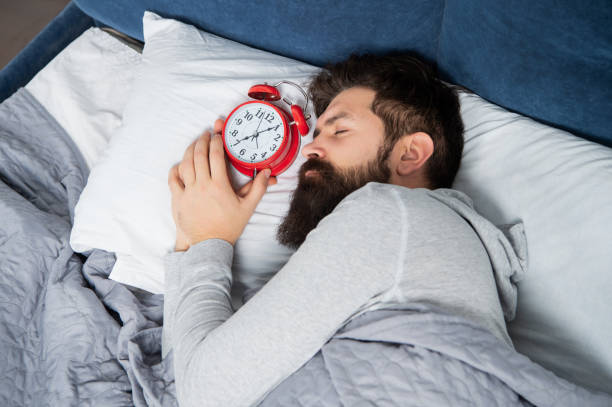 istock Man sleeping with alarm clock in bed, sleep time 1372095372
