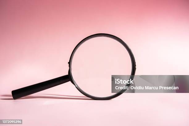 A Black Magnifying Glass On A Pink Background Concept Of Search Research Looking For Something Stock Photo - Download Image Now
