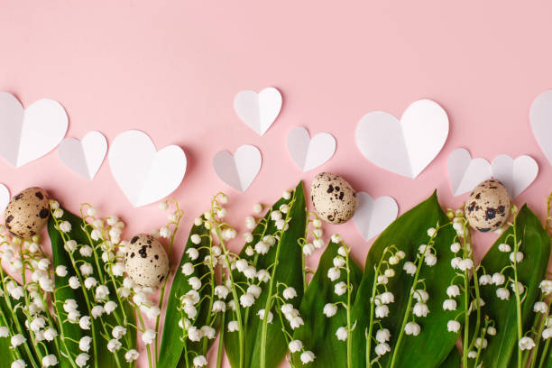 istock Spring Easter holiday pink background with wild may-lily, quail eggs, paper hearts. Banner for your site with copy space. Top view, Seasonal greeting card, flyer, invitation 1372095490