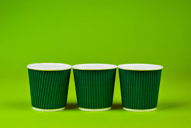 istock Disposable paper cups on a green background. Ecological coffee utensils. Copy space and free space for text near the glasses. 1372095762