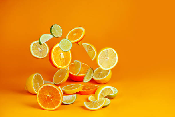 istock Oranges, lemons and limes cut into slices. Citrus vegetables fly on an orange background. Preparing vegetables for juice and cocktails. Copy space and free space for text near food. 1372095768