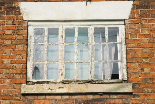 Window in the yellow wall of the old demolished house