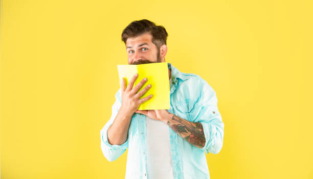 istock funny positive bearded man behind planner on yellow background, fun 1372096687