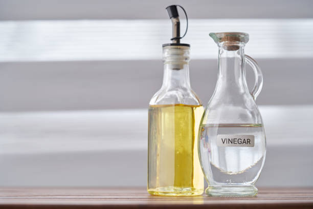 vinaigre blanc et huile d’olive sur plateau de table en bois - vinegar bottle herb white photos et images de collection