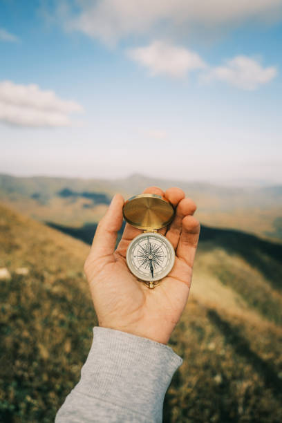 istock Vintage compass in a hand in mountains. 1372097369
