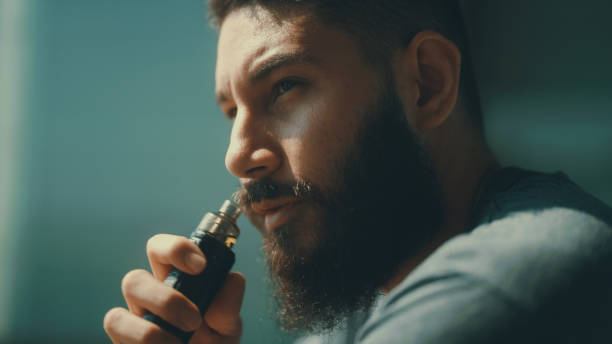 istock Man smoking in front of balcony to relieve stress from work. 1372098119